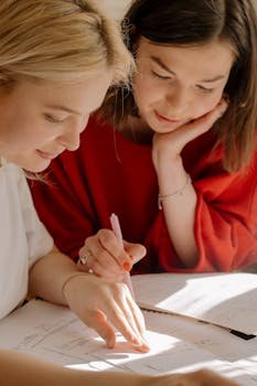 Two college students studying together, focusing on exam preparation in a bright setting.